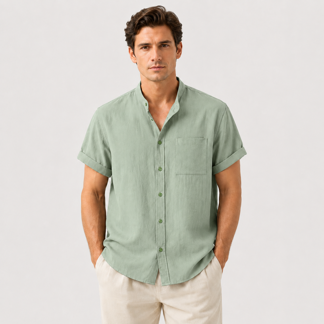 Man wearing a light green short-sleeve shirt with a neutral background