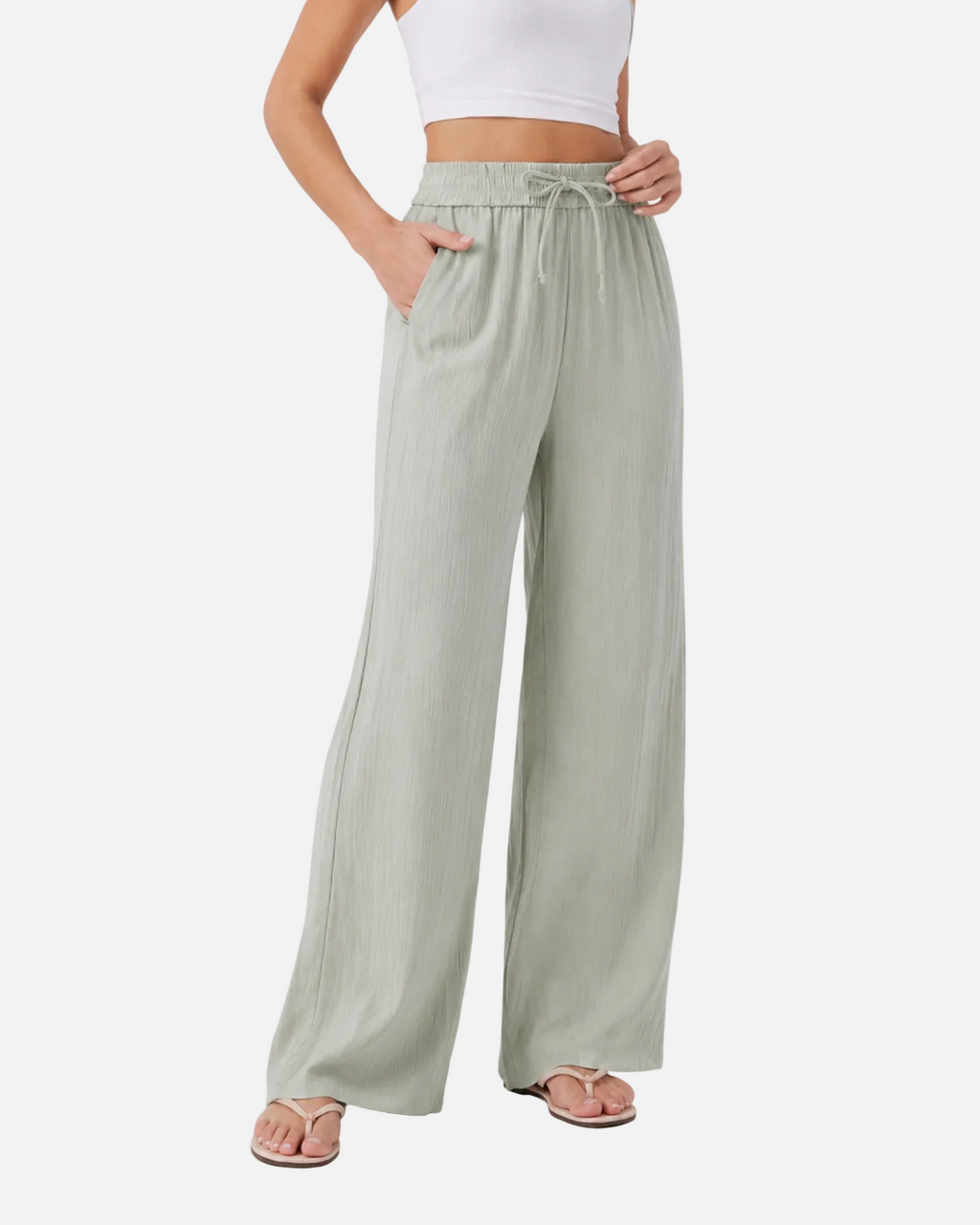 Person wearing light green wide-leg pants on a white background