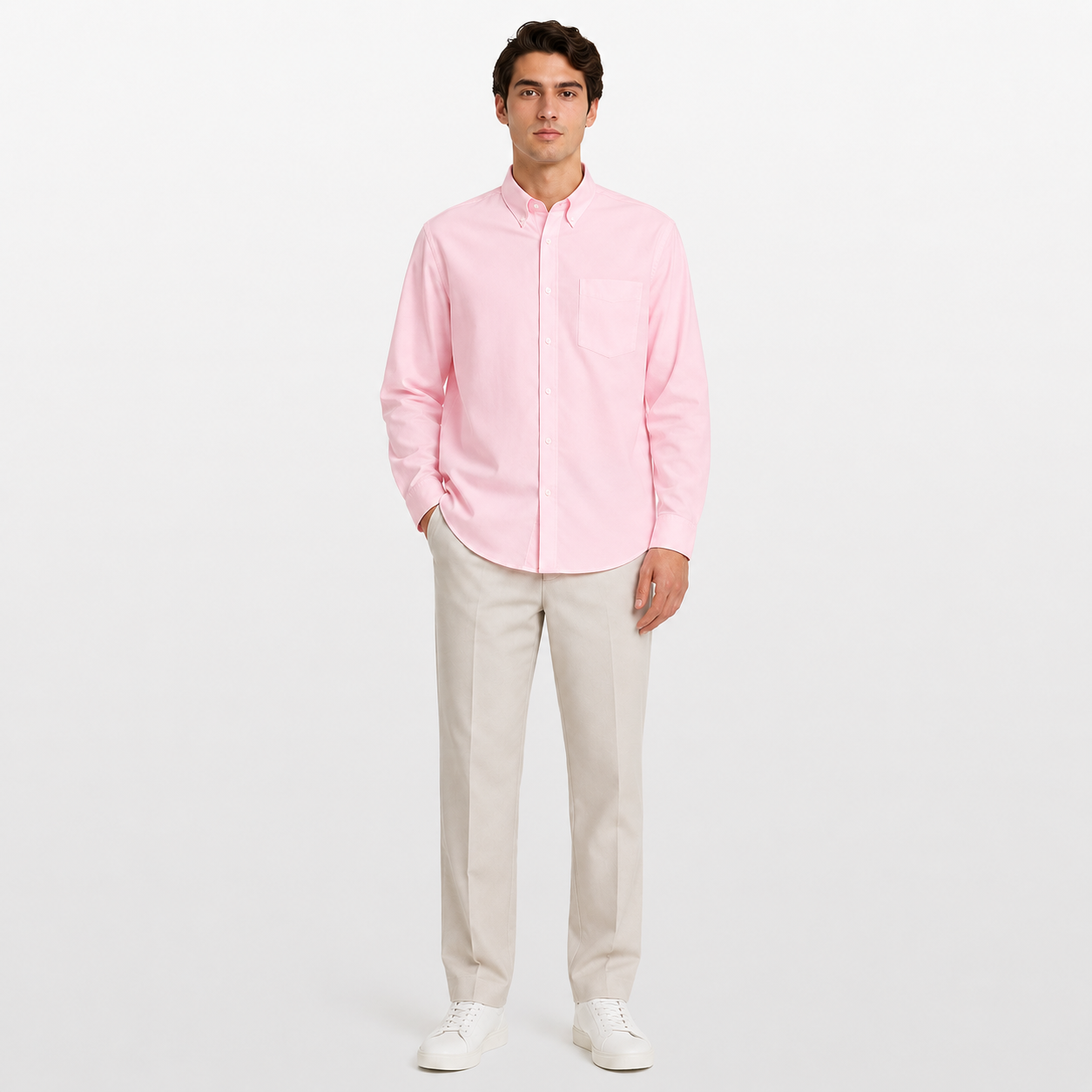 Man wearing a light pink button-up shirt and beige pants on a white background
