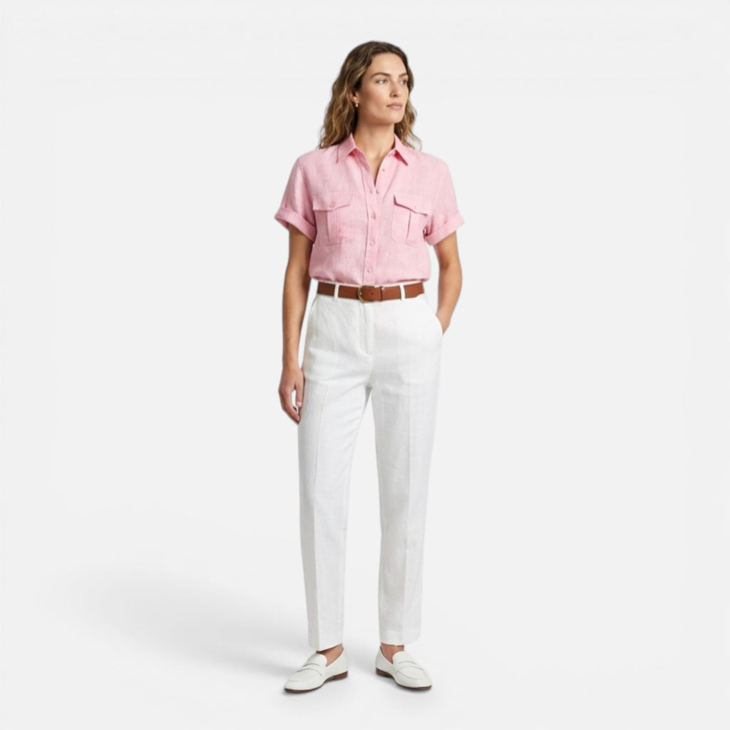 Woman wearing a pink shirt and white pants on a white background