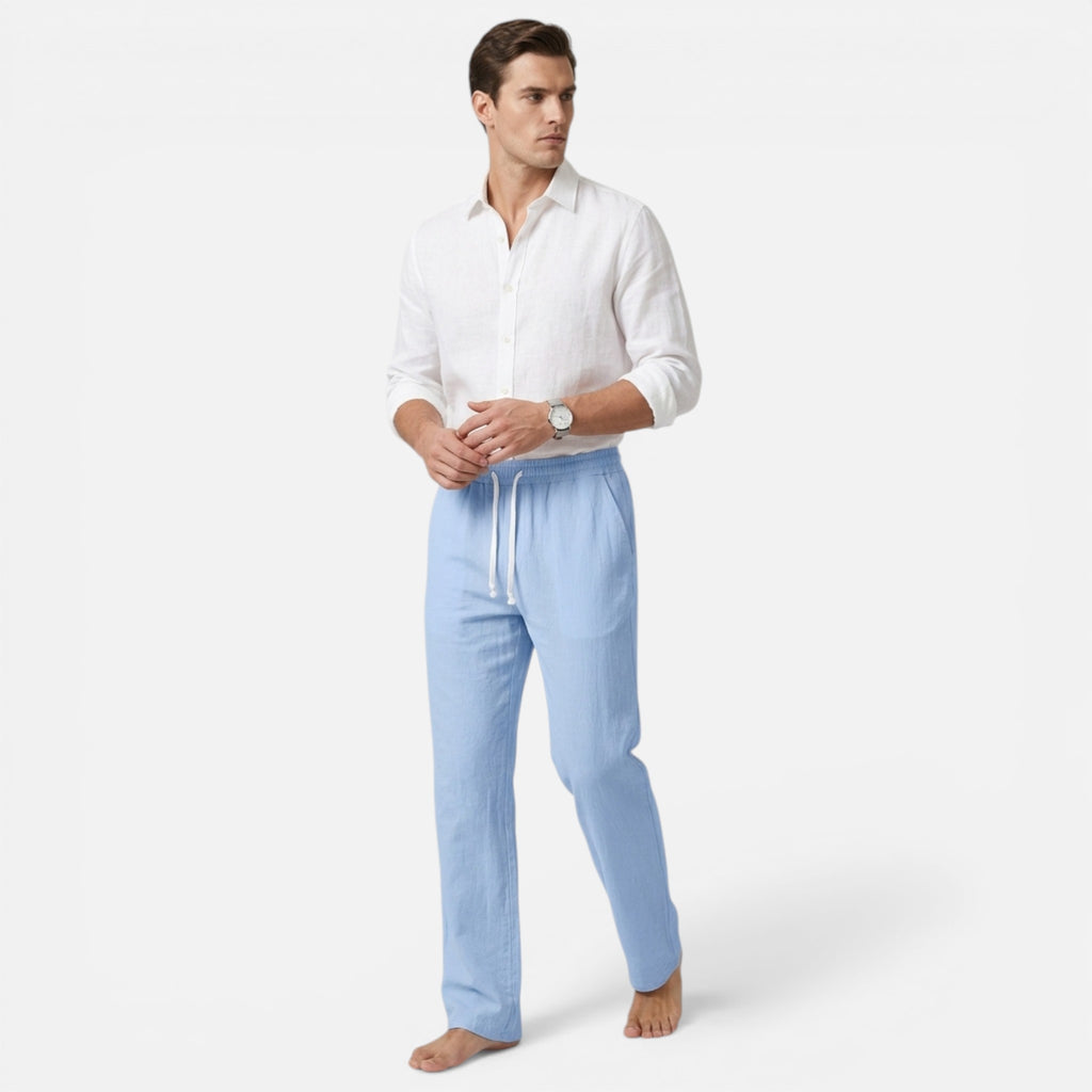 Man wearing a white shirt and light blue pants on a white background