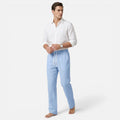 Man wearing a white shirt and light blue pants on a white background