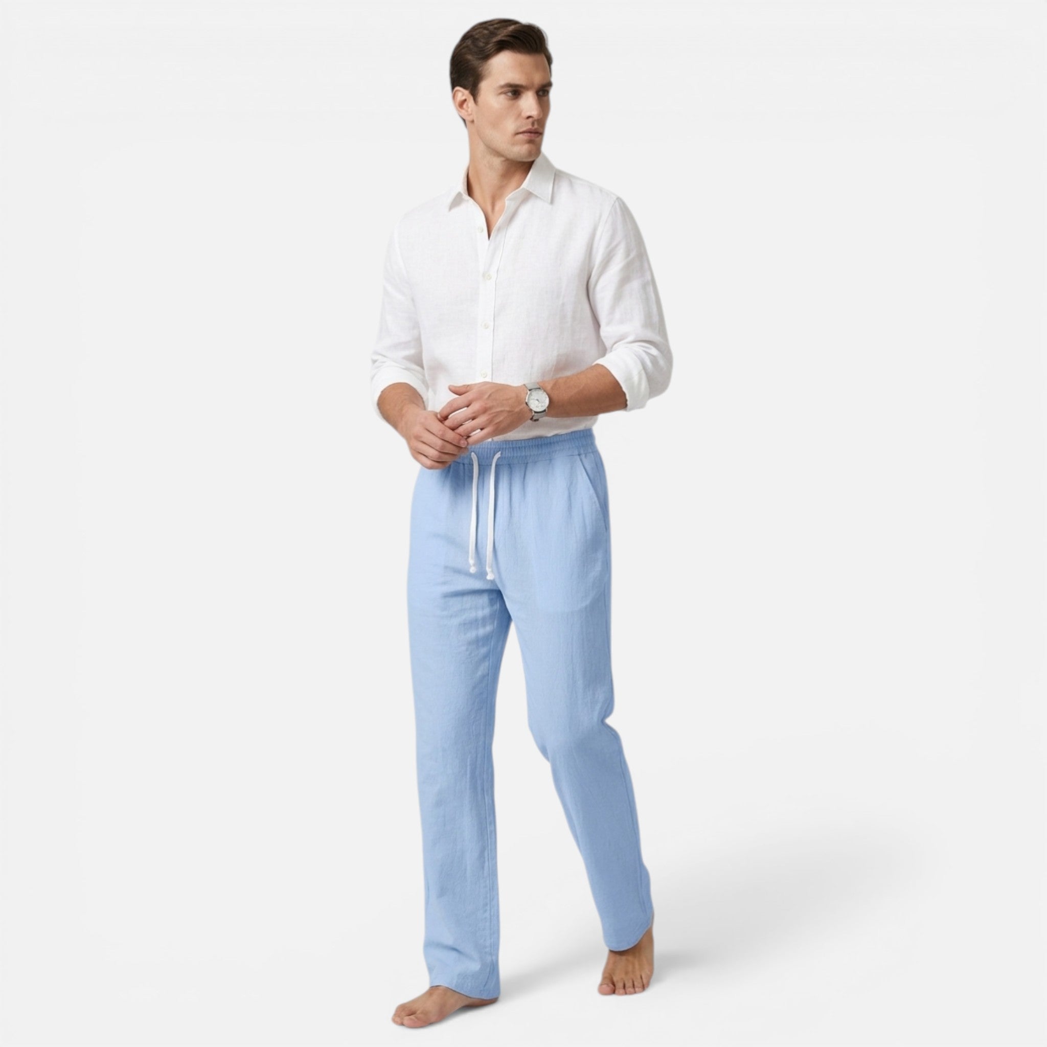 Man wearing a white shirt and light blue pants on a white background