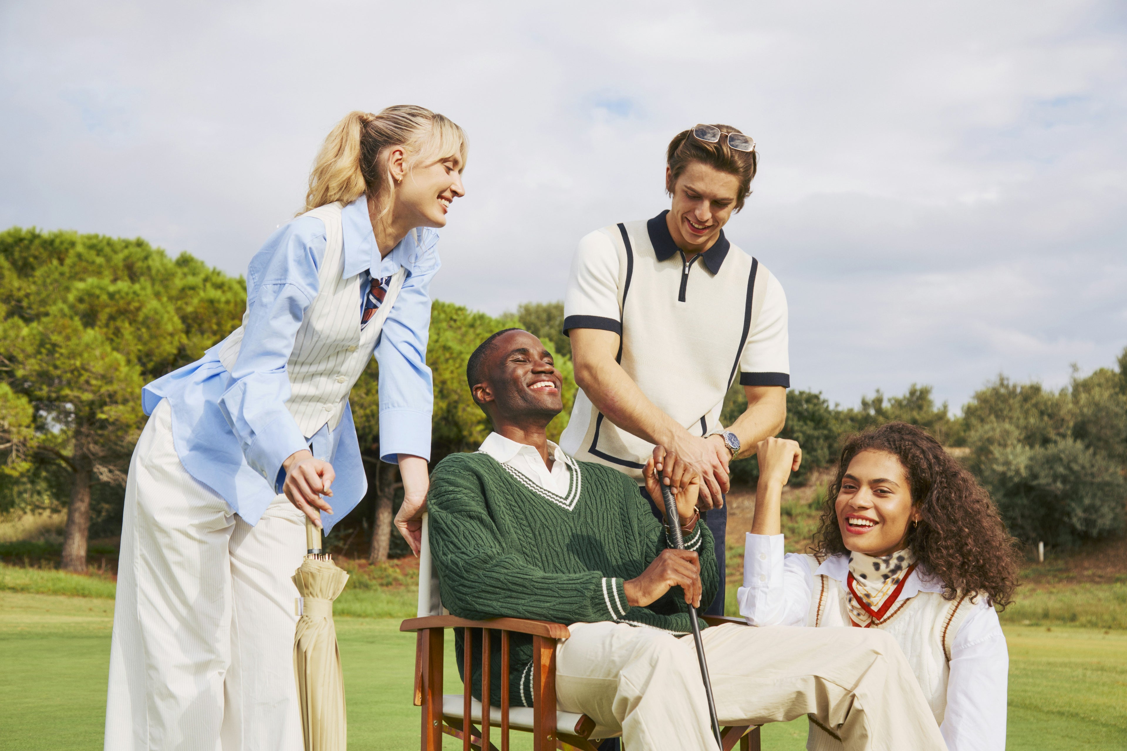 Four people on a golf course with one person holding a golf club