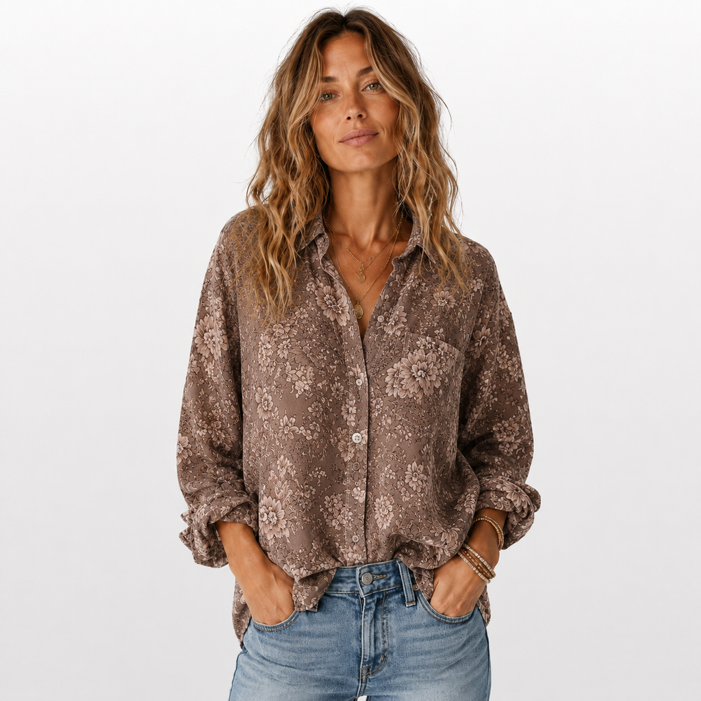 Woman wearing a patterned brown shirt and jeans on a white background