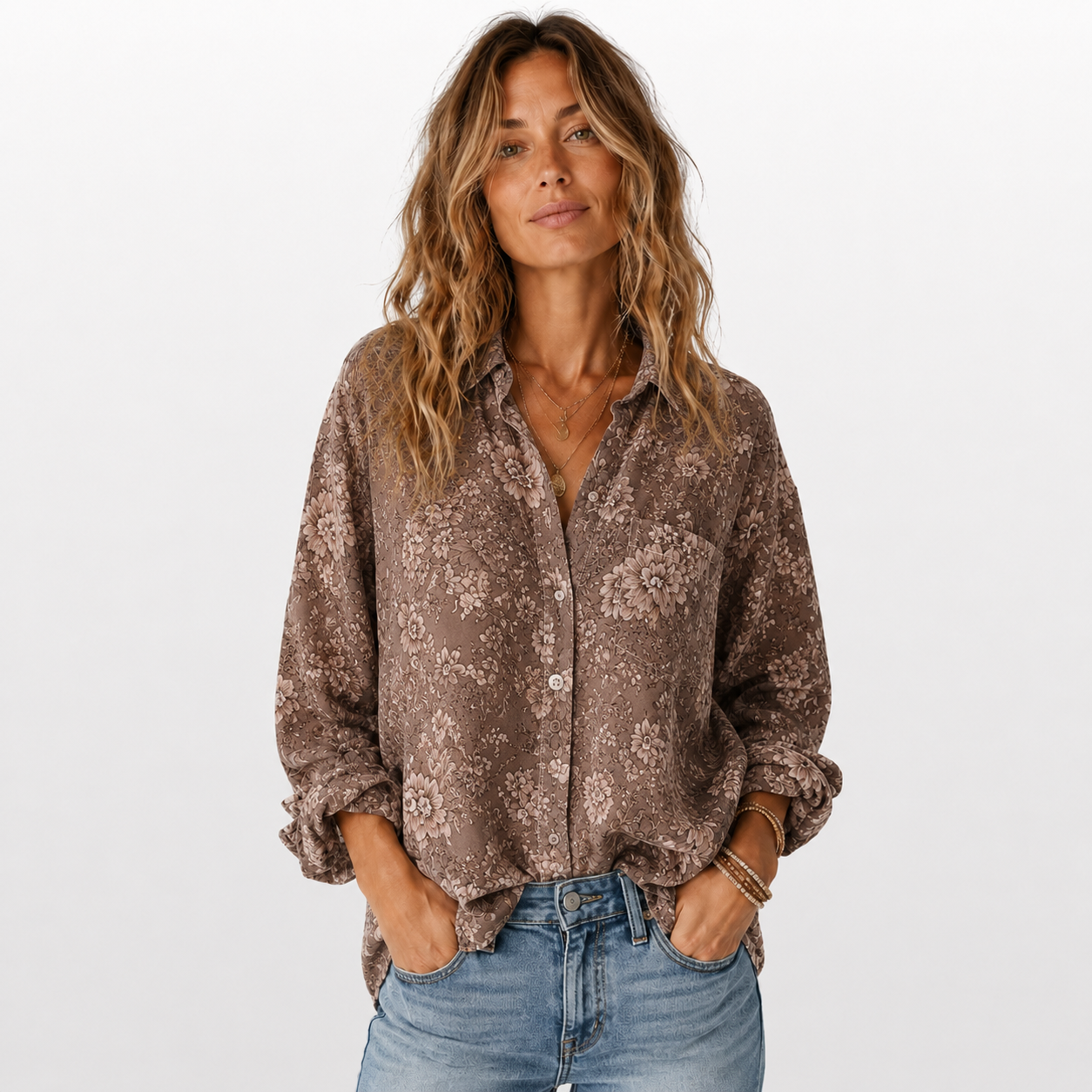 Woman wearing a patterned brown shirt and jeans on a white background