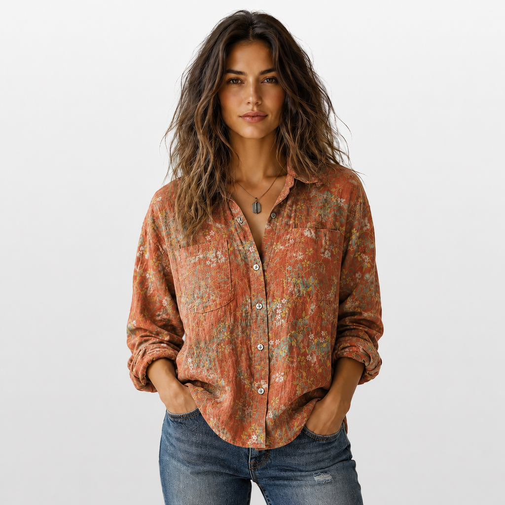 Woman wearing a patterned shirt and jeans on a plain background