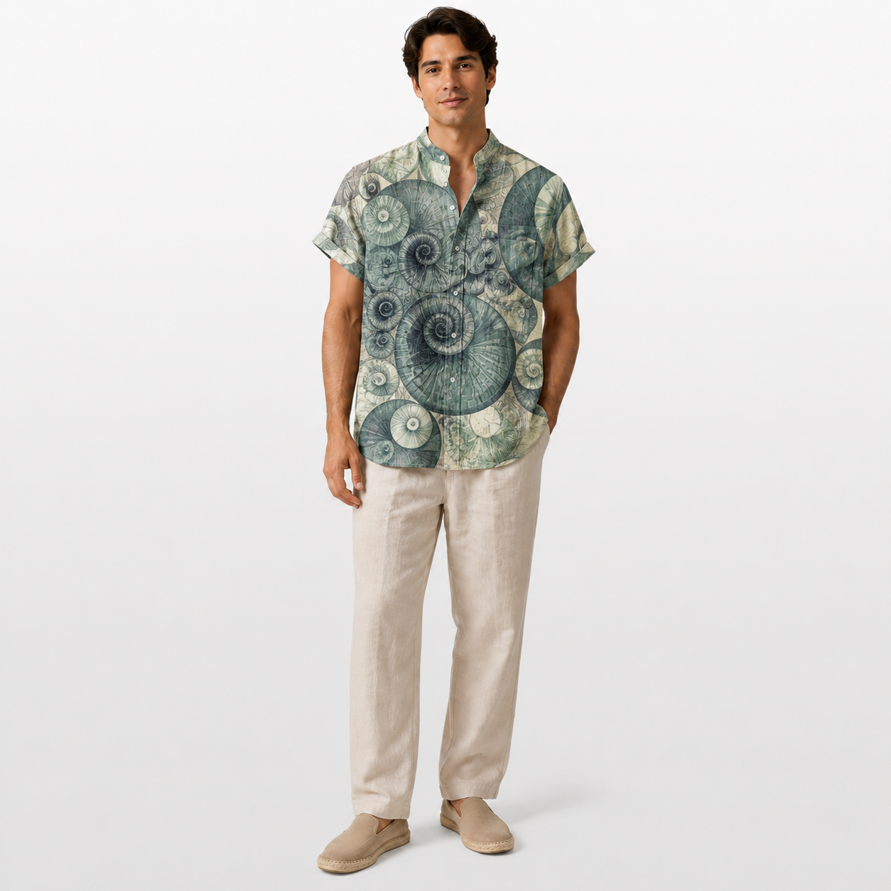 Man wearing a patterned shirt and beige pants on a white background