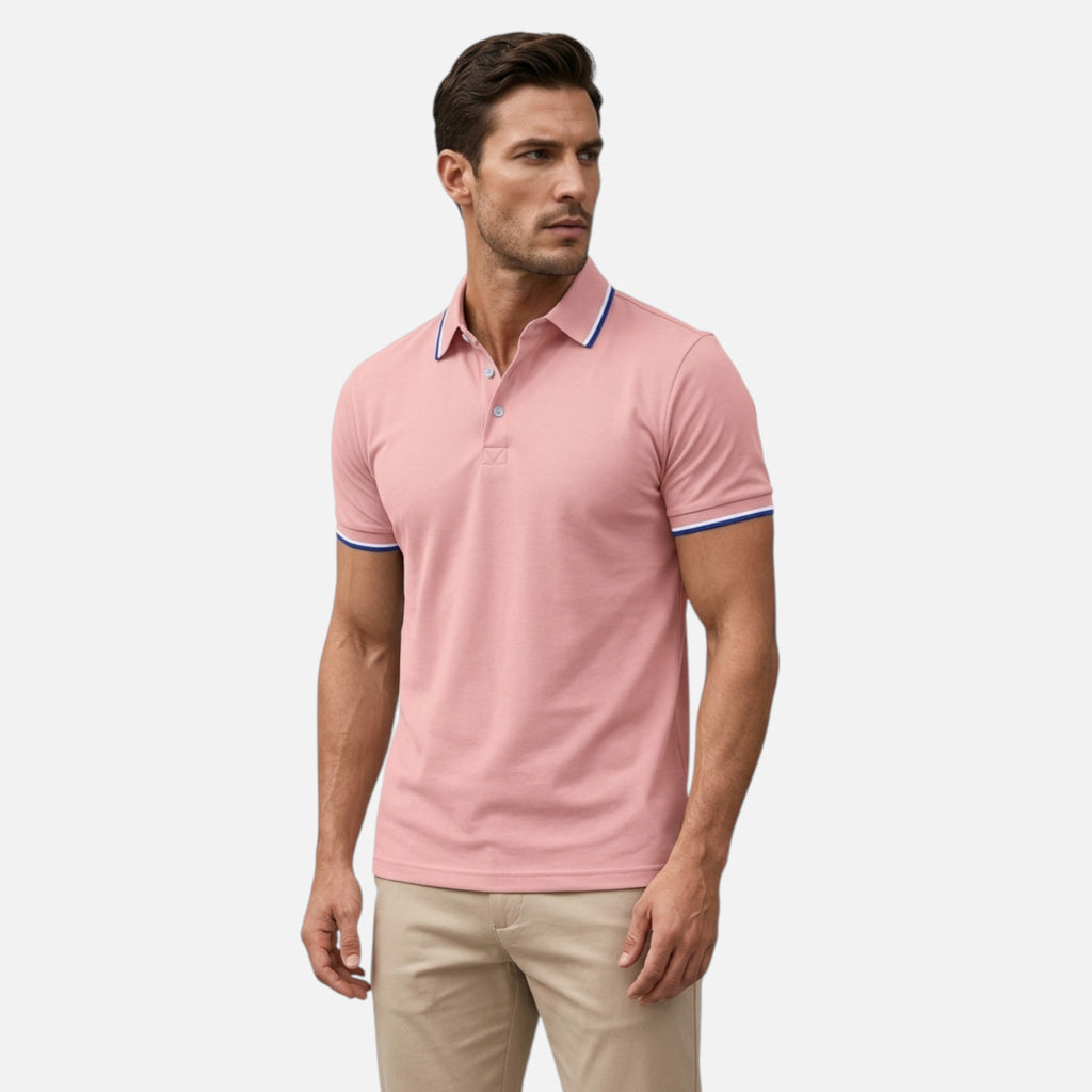 Man wearing a pink polo shirt with white pants on a light gray background