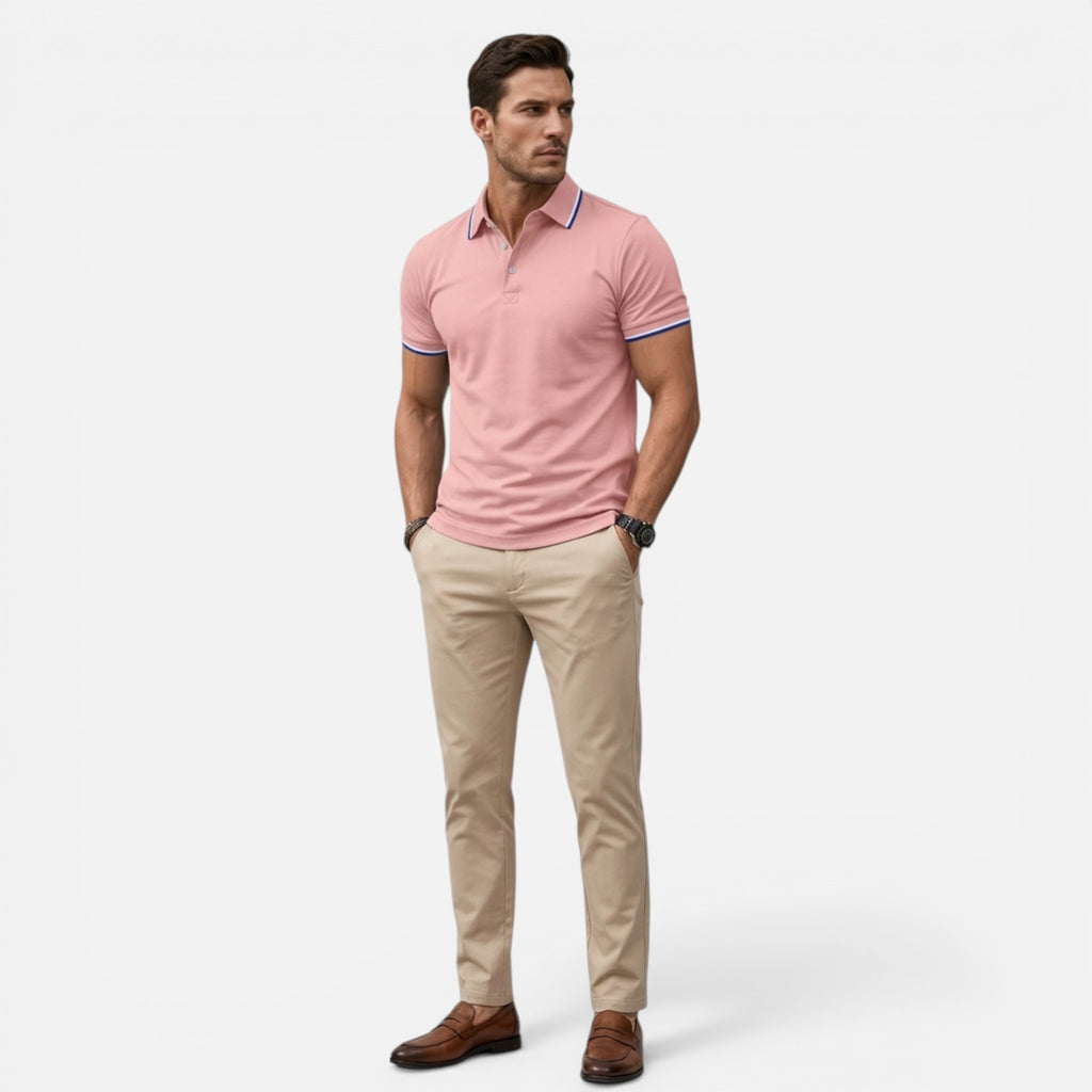 Man wearing a pink polo shirt and beige pants on a white background