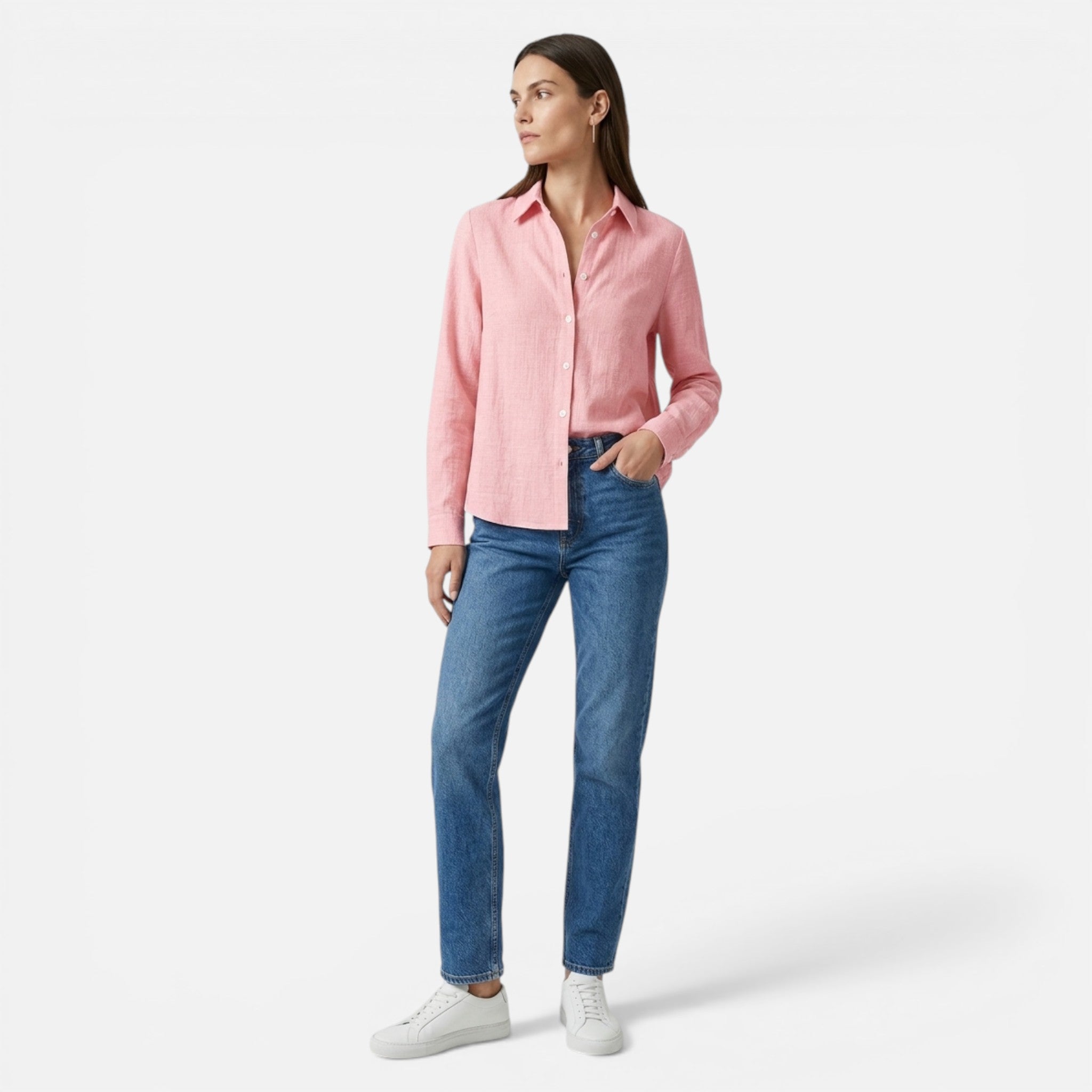 Woman wearing a pink shirt and blue jeans on a white background