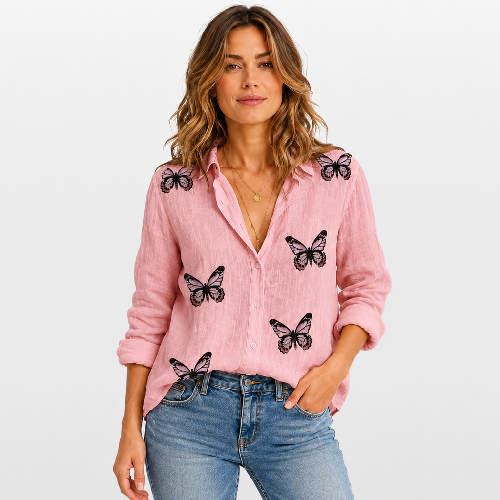 Woman wearing a pink shirt with black butterfly patterns and blue jeans on a white background
