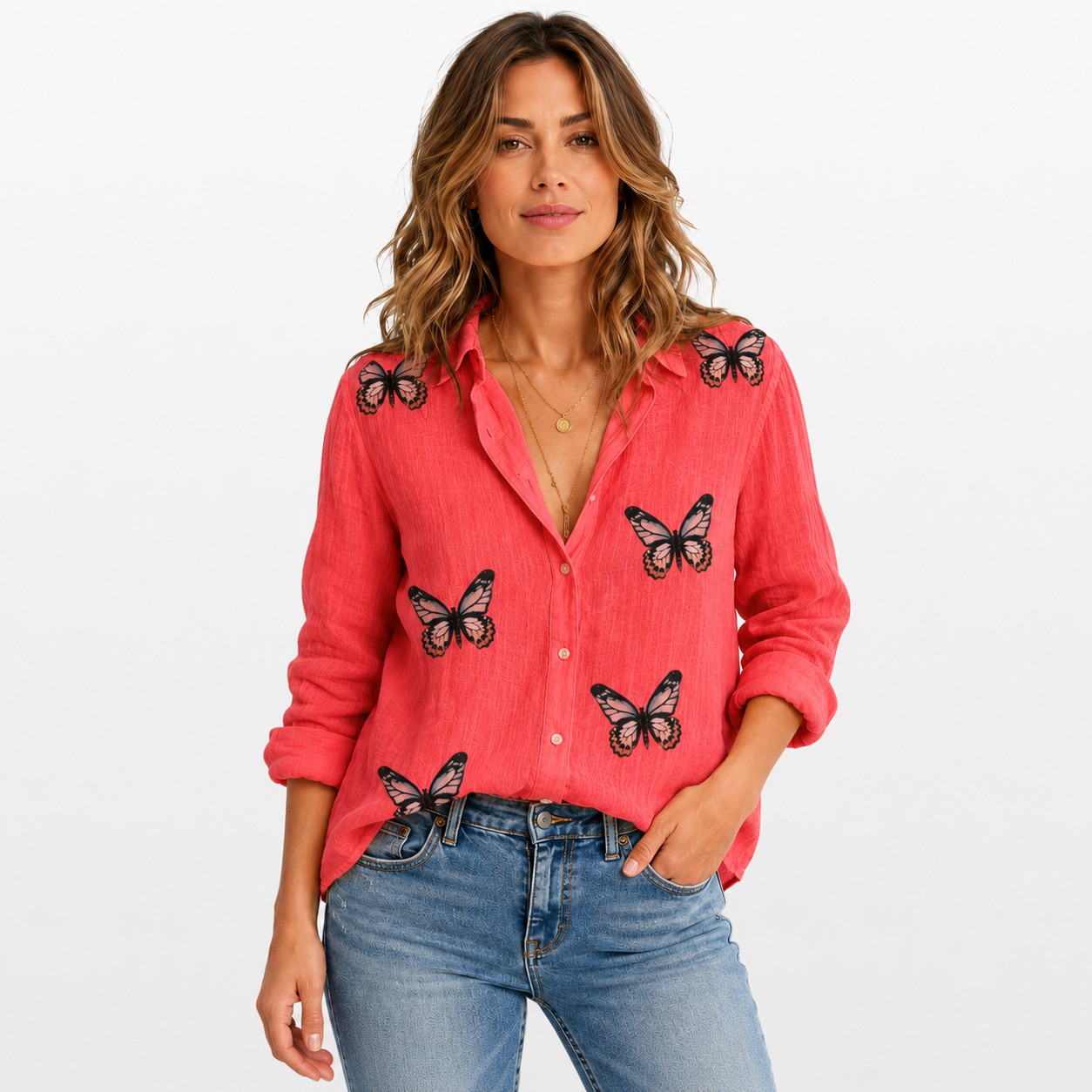 Woman wearing a pink shirt with butterfly designs and blue jeans on a white background
