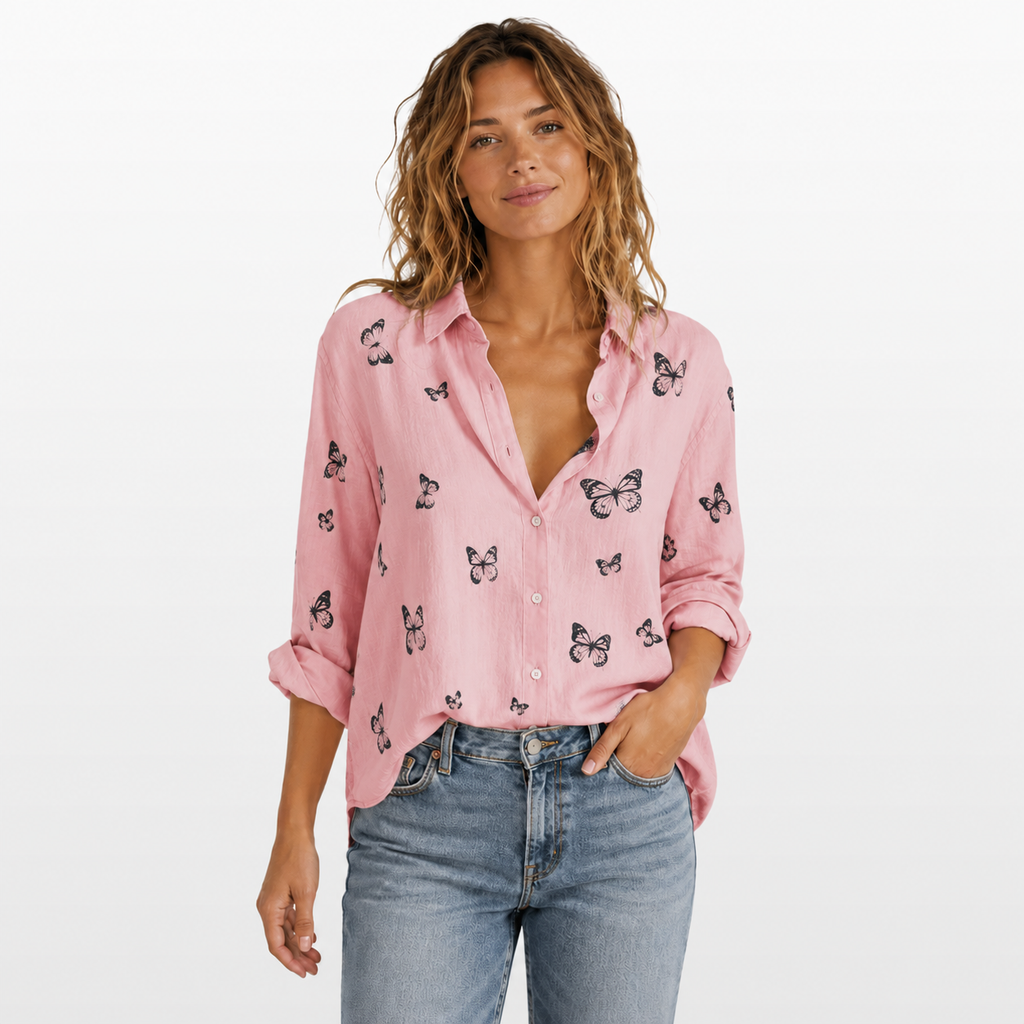 Woman wearing a pink shirt with butterfly patterns and blue jeans on a white background