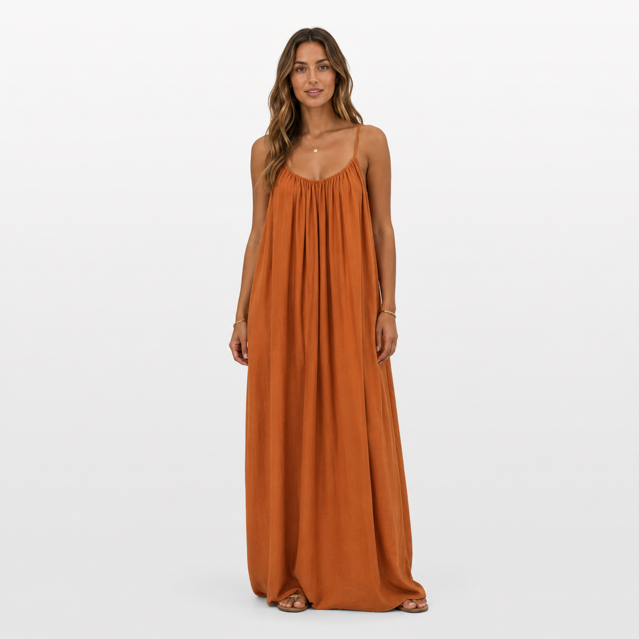 Woman wearing a rust-colored maxi dress on a white background