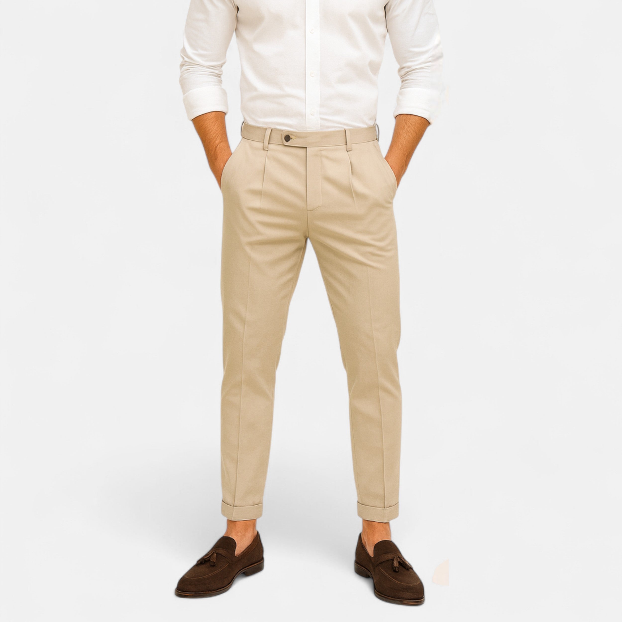 Person wearing beige pants and a white shirt on a plain background