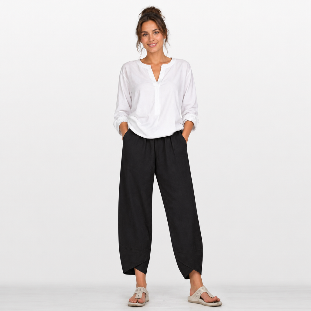 Woman wearing a white blouse and black pants on a white background