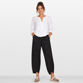 Woman wearing a white blouse and black pants on a white background