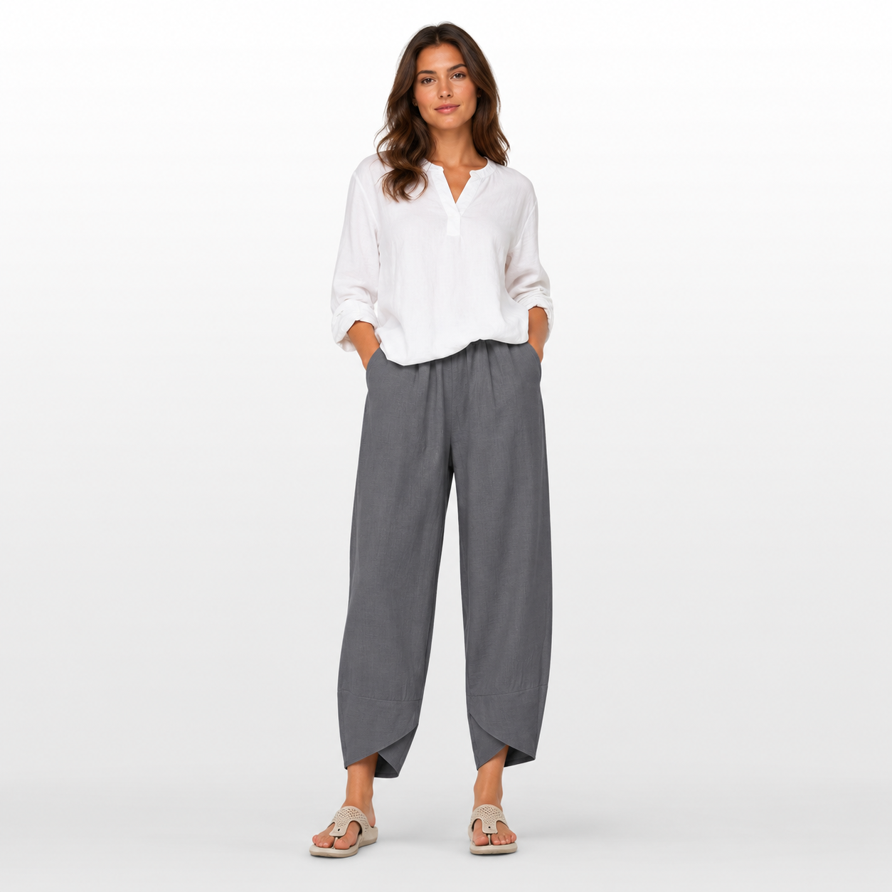 Woman wearing a white blouse and gray pants on a white background
