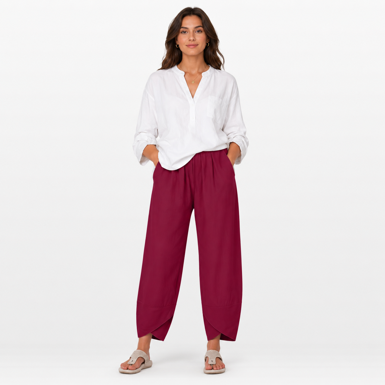 Woman wearing a white blouse and red pants on a white background