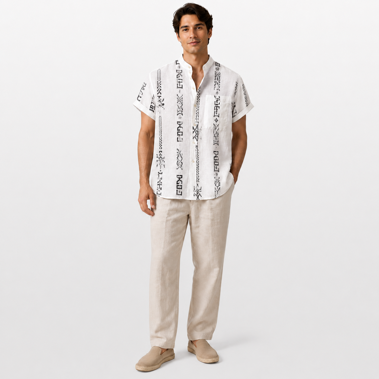Man wearing a white embroidered shirt and beige pants on a white background