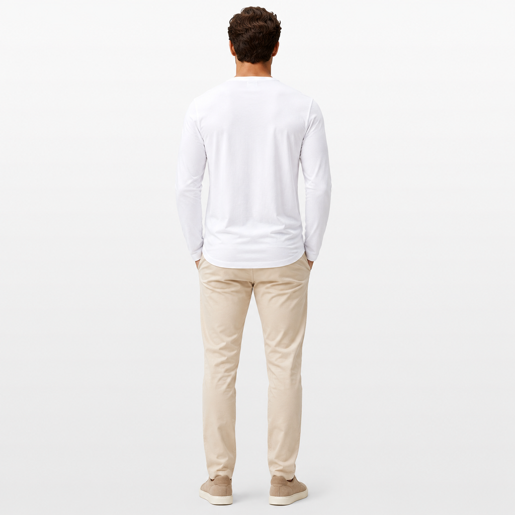 Man wearing a white long-sleeve shirt and beige pants on a light gray background