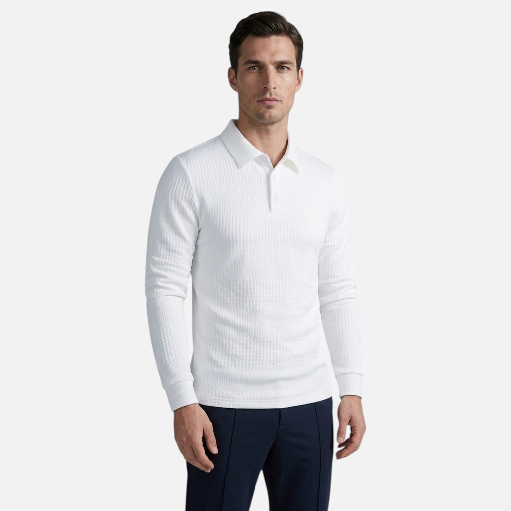 Man wearing a white ribbed sweater and dark pants on a light gray background