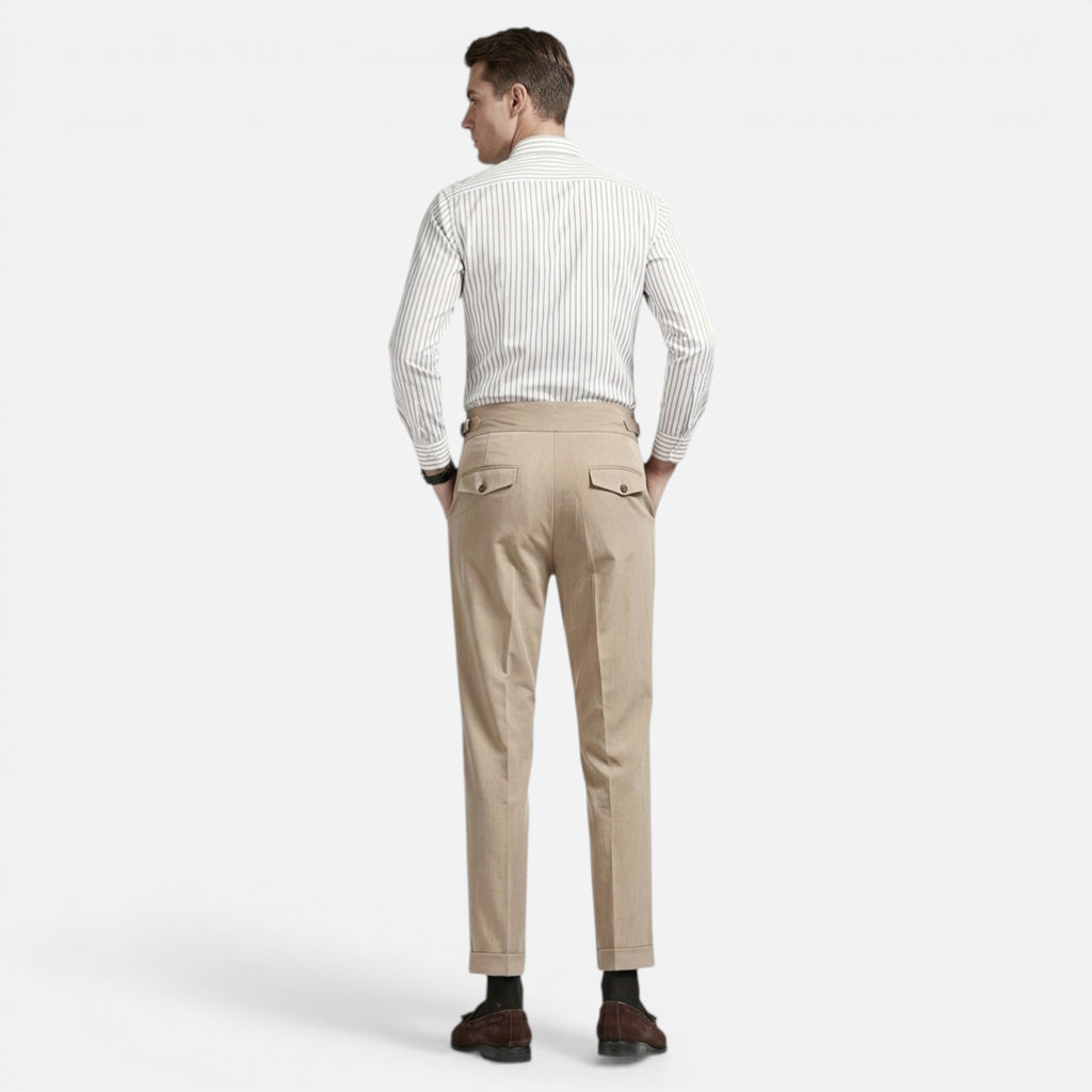 Man wearing a white shirt and beige pants on a white background