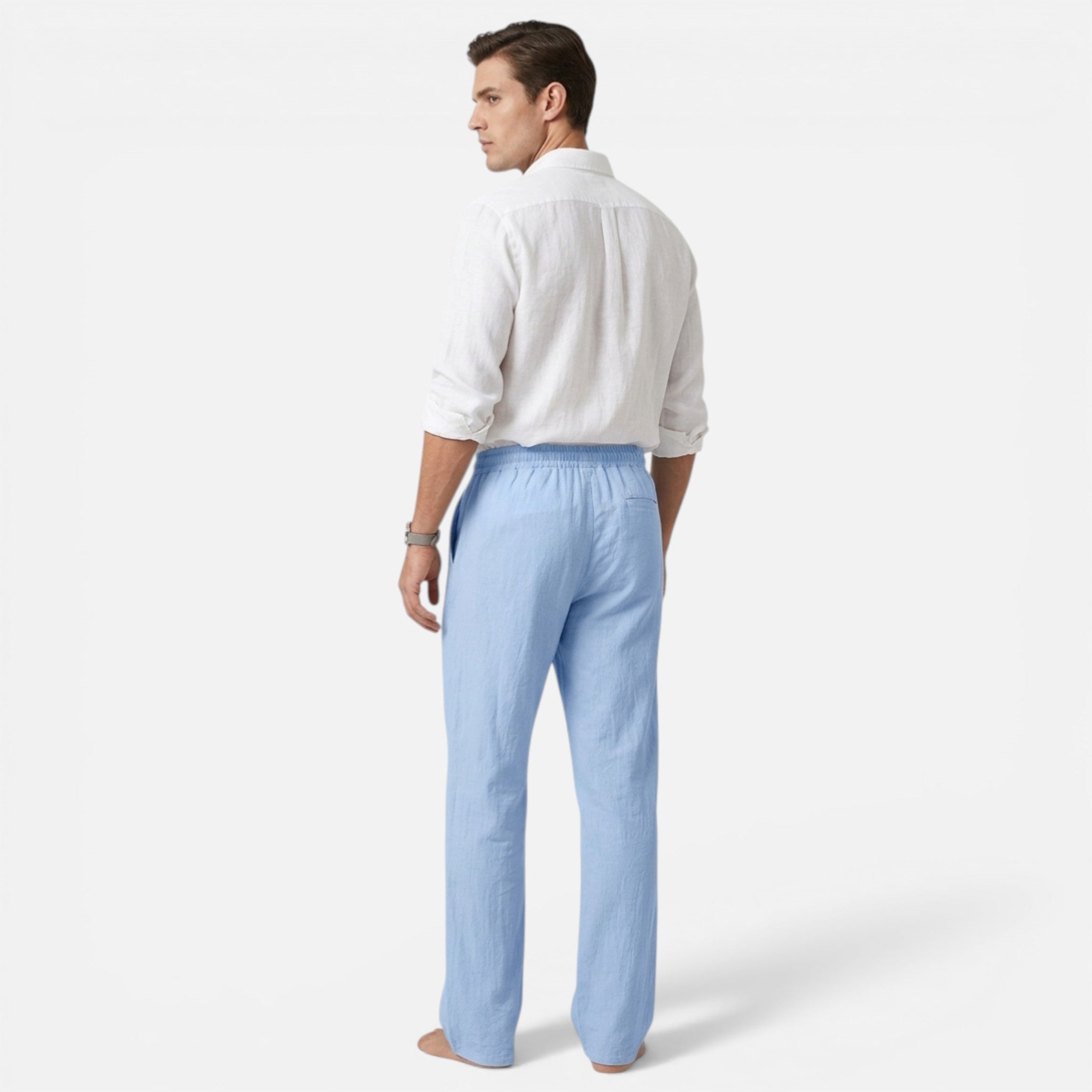 Man wearing a white shirt and light blue pants on a white background