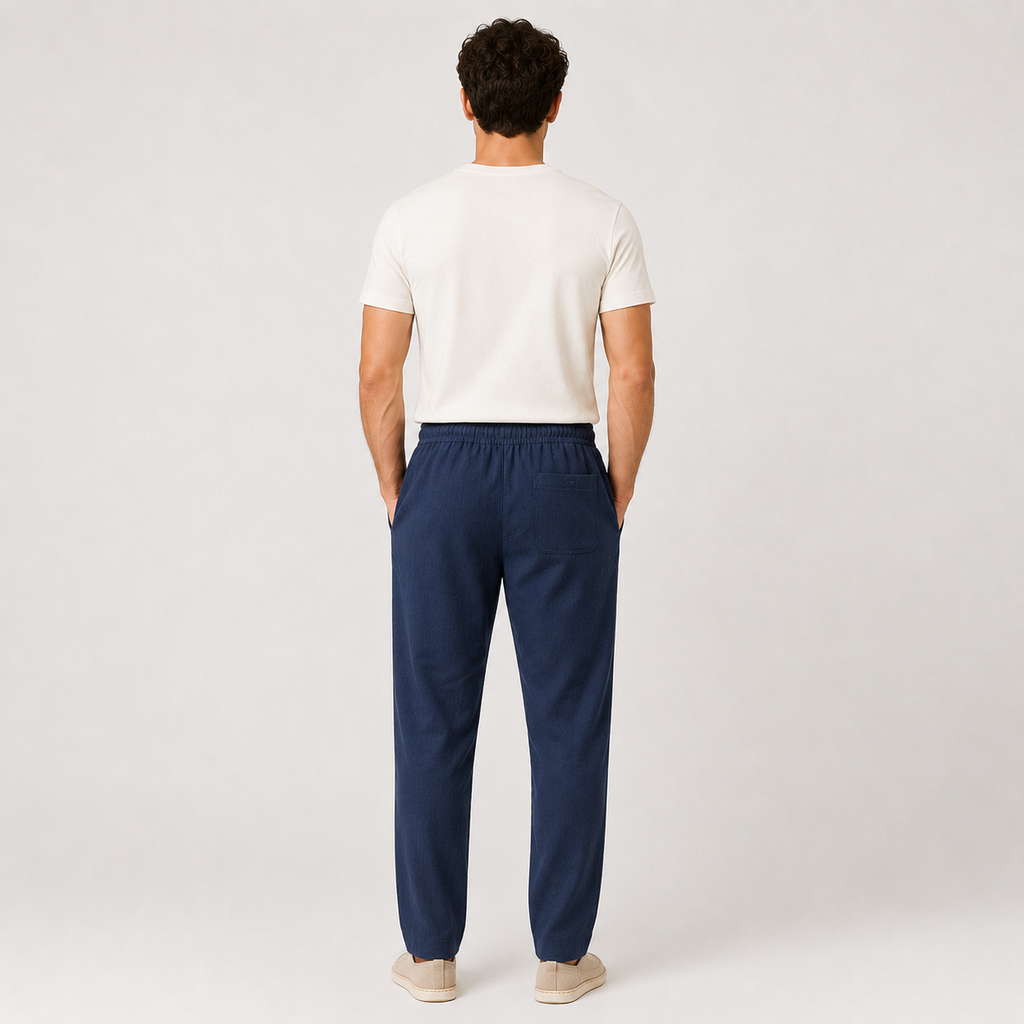 Person wearing navy pants and a white shirt on a plain background