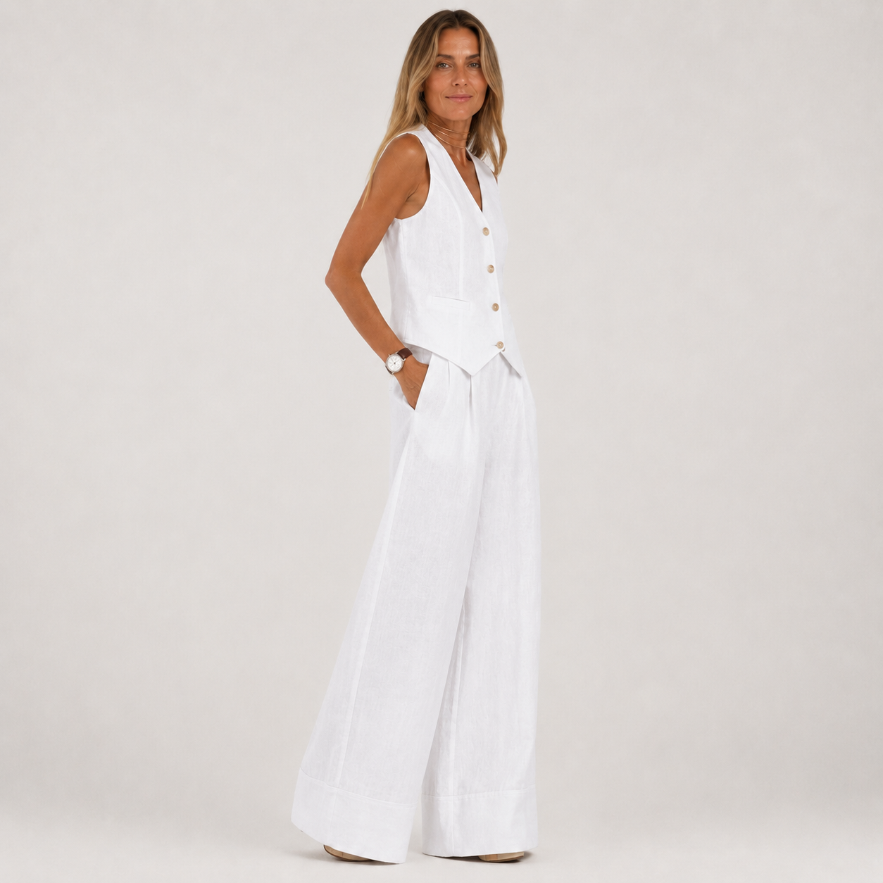Woman wearing a white sleeveless dress on a plain background