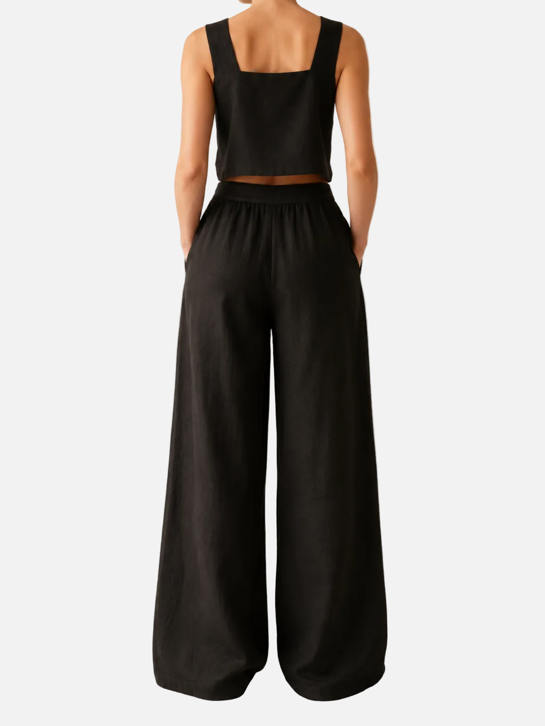 Person wearing a black sleeveless top and wide-leg pants on a beige background