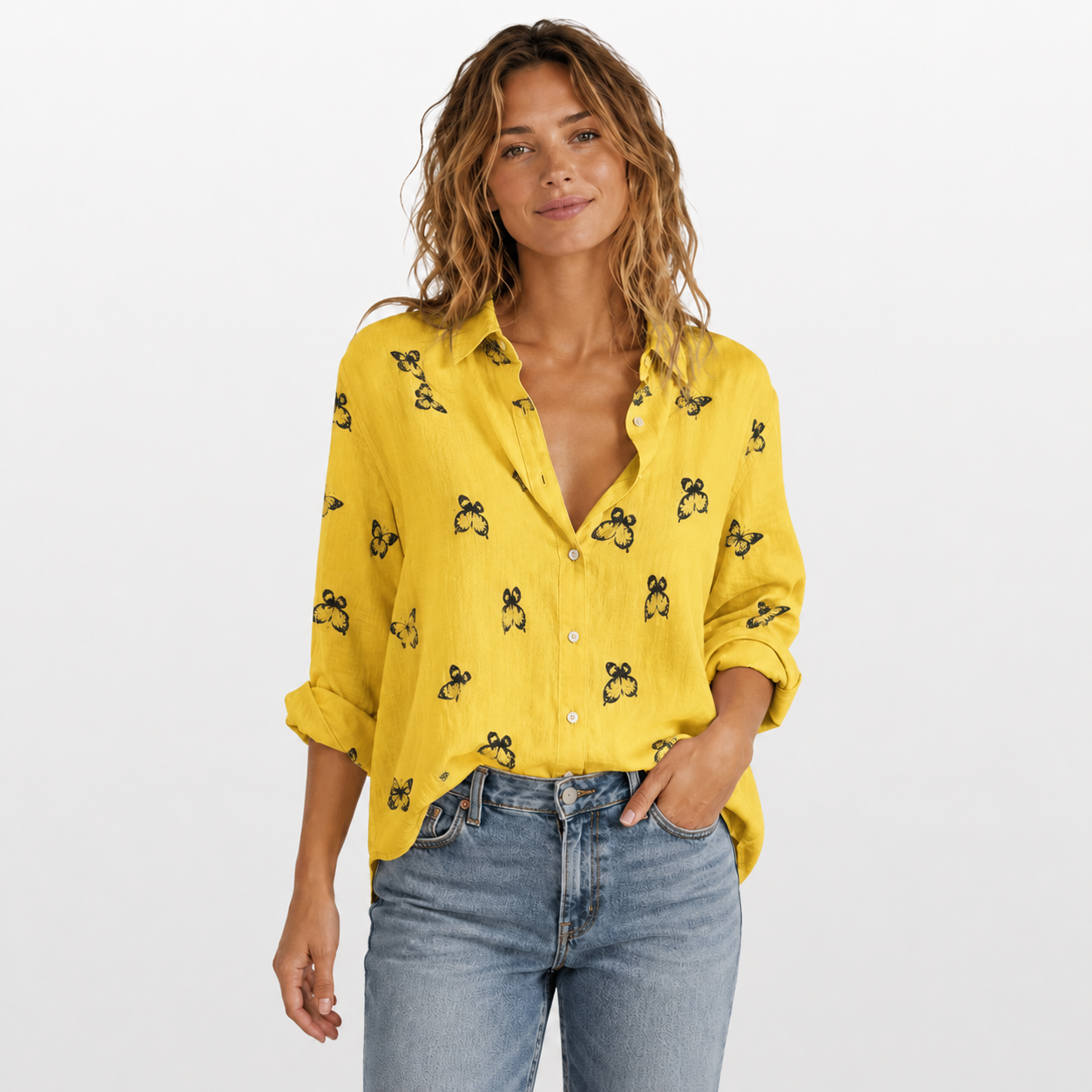 Woman wearing a yellow blouse with black patterns and blue jeans on a white background