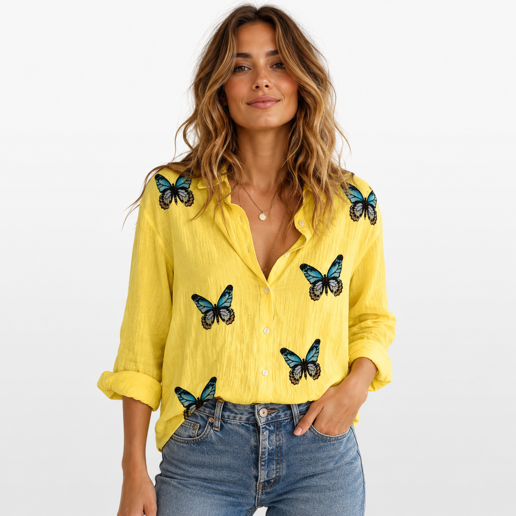 Woman wearing a yellow shirt with butterfly designs on a white background