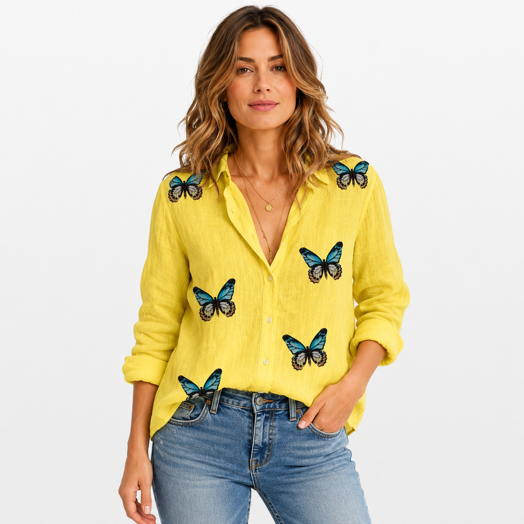 Woman wearing a yellow shirt with butterfly designs on a white background